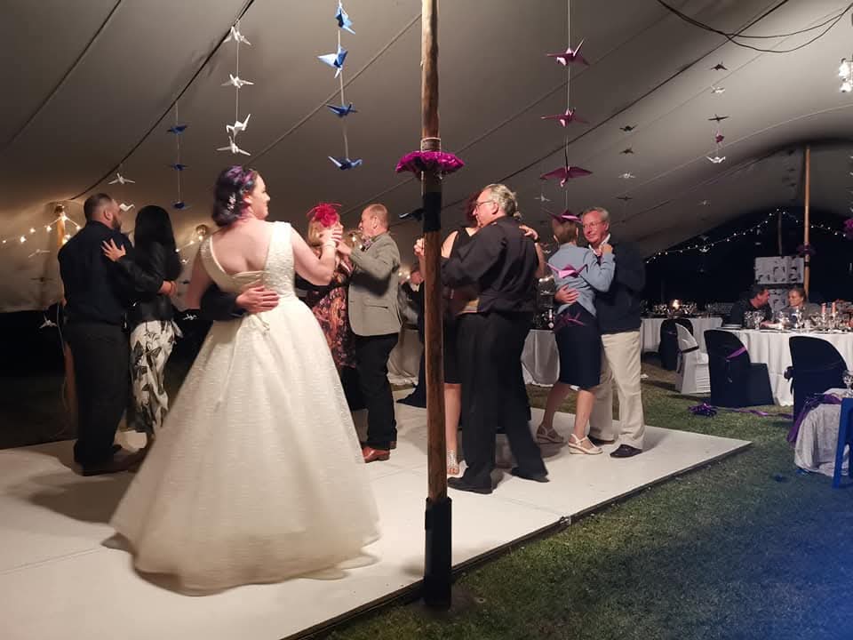Bride and guests dancing at an outdoor wedding reception