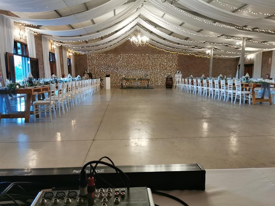 Draped wedding hall with long tables and fairy lights