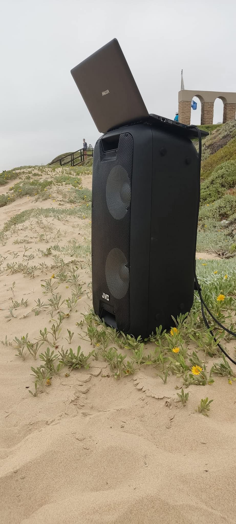 Speaker and laptop setup on sand for a beach event