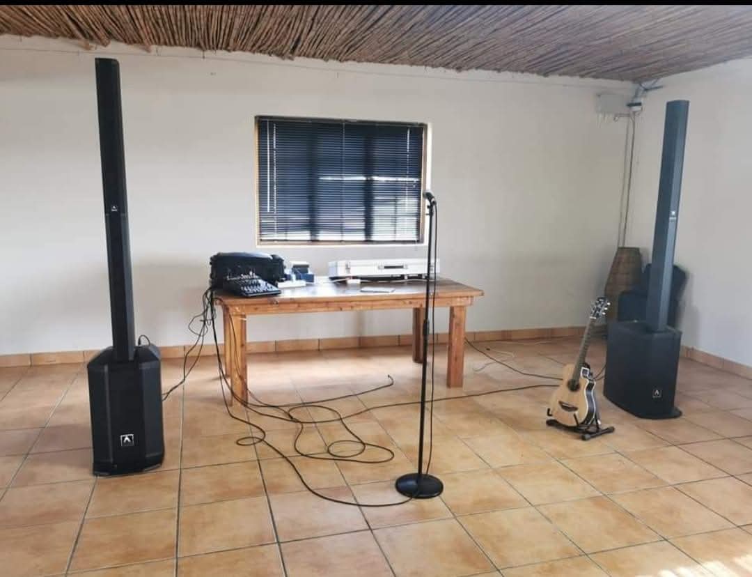 Compact sound hire setup in a simple indoor room with microphone and guitar