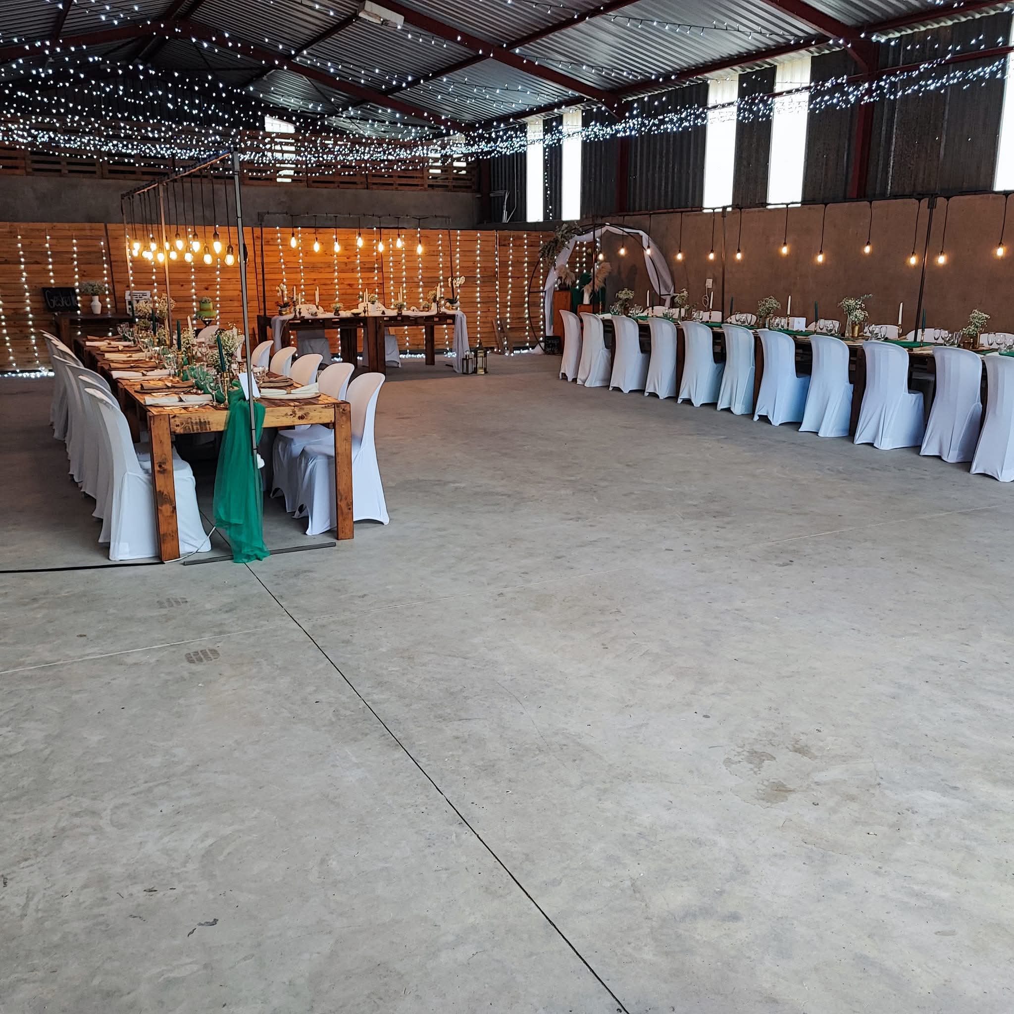 Wedding venue interior prepared with string lights and decorated tables