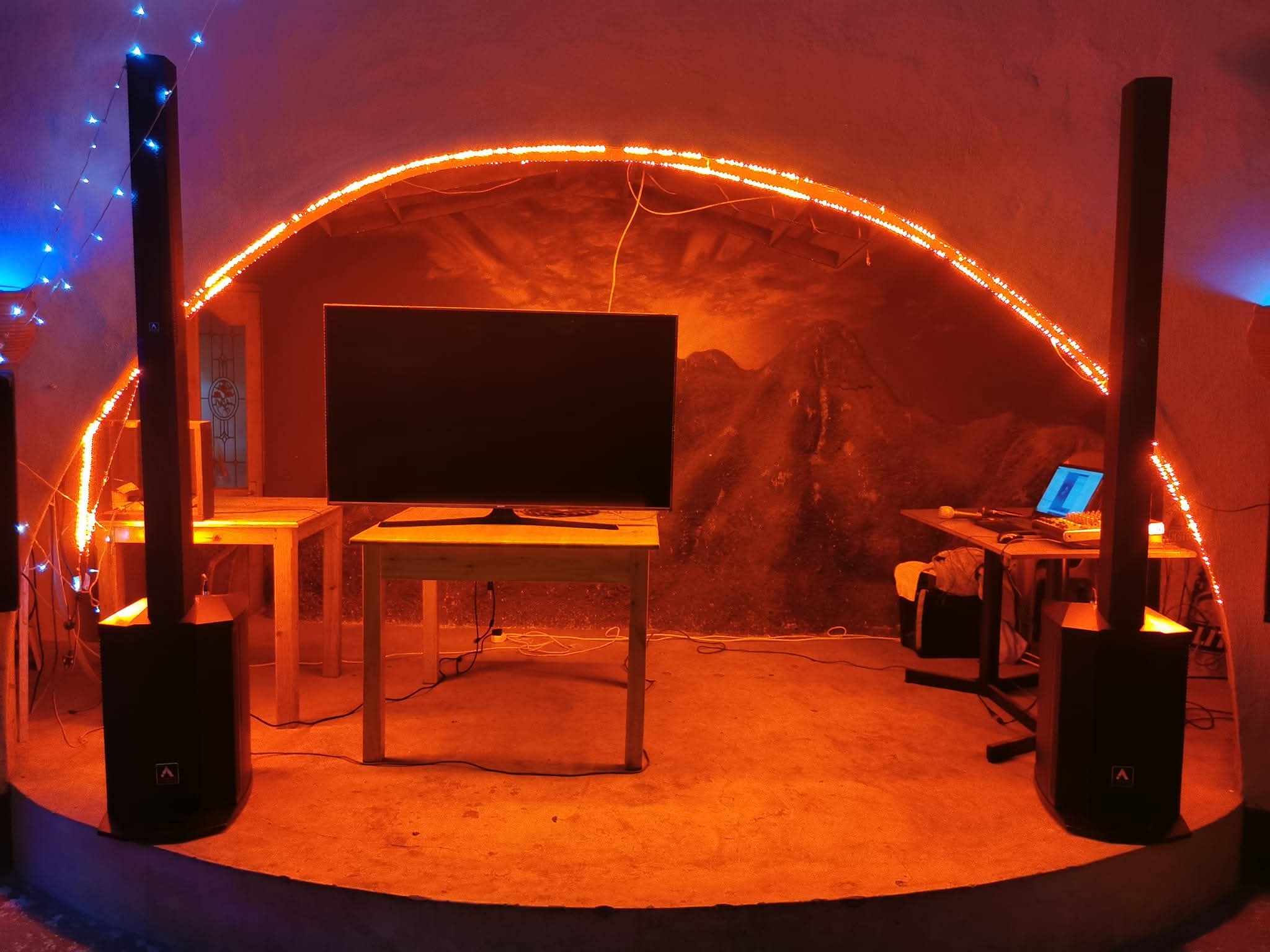 Orange-lit speaker and screen setup for indoor entertainment