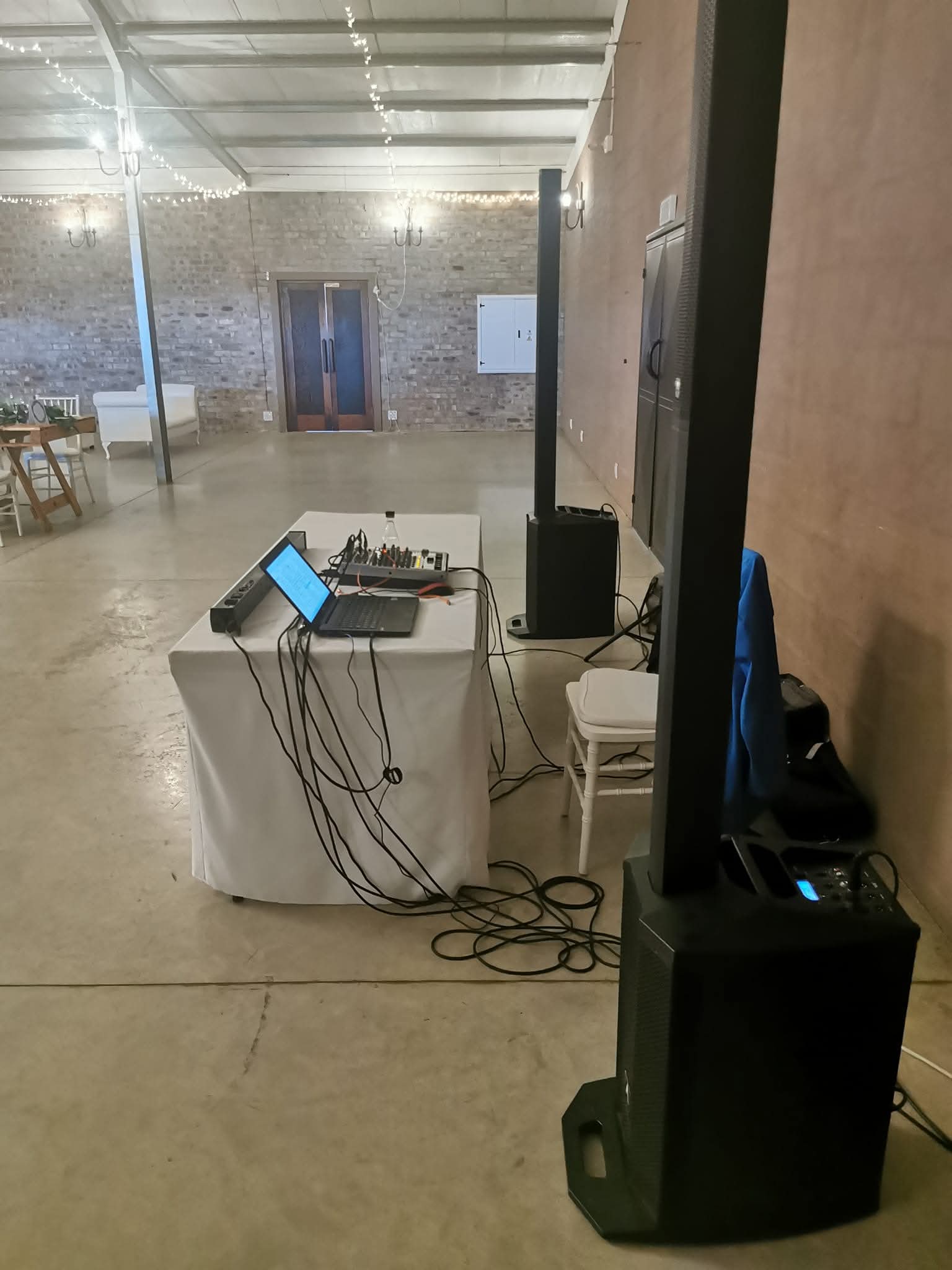 Speaker columns and mixer table in a large indoor venue