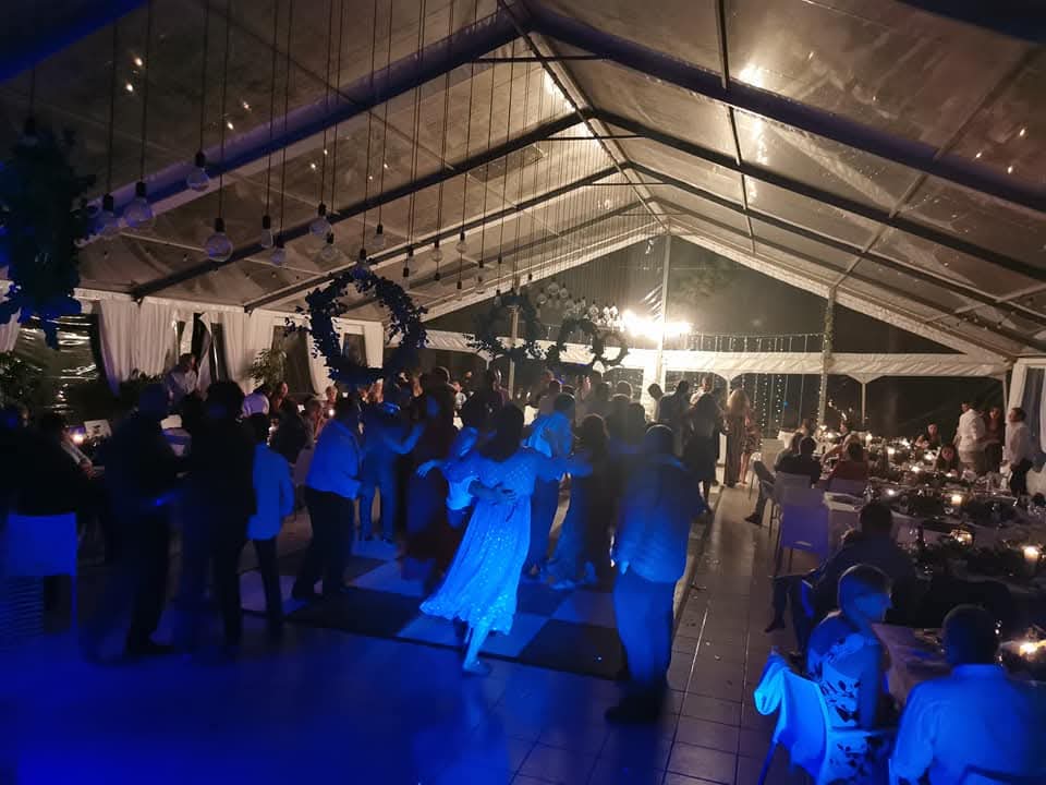 Wedding dancefloor with bride and guests dancing under event lighting
