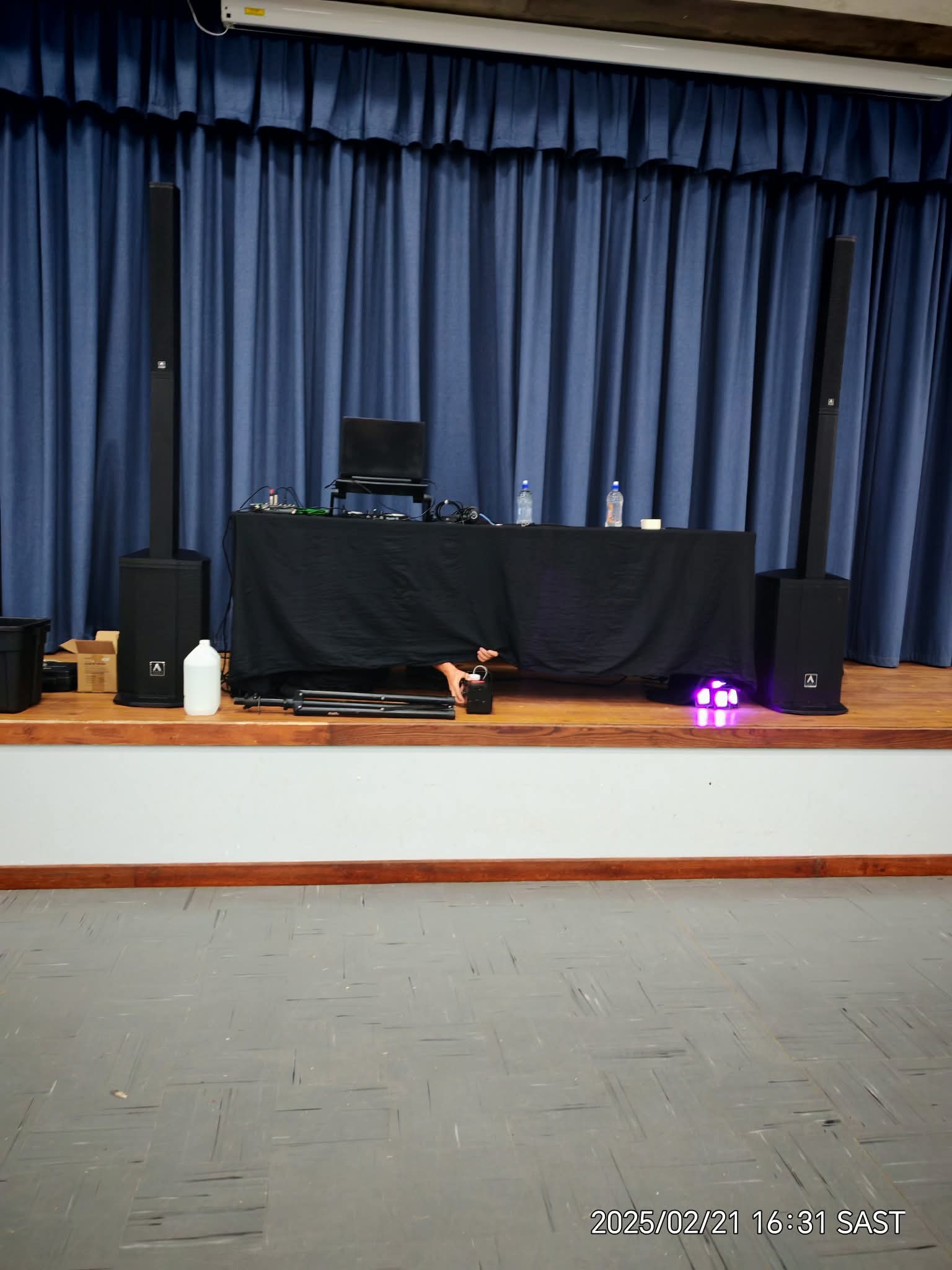 Hall PA setup with speaker columns and DJ table
